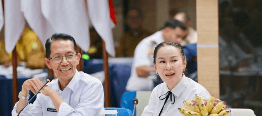 Amsakar Achmad dan Li Claudia Chandra duduk berdampingan dalam rapat resmi pemerintahan di Batam.